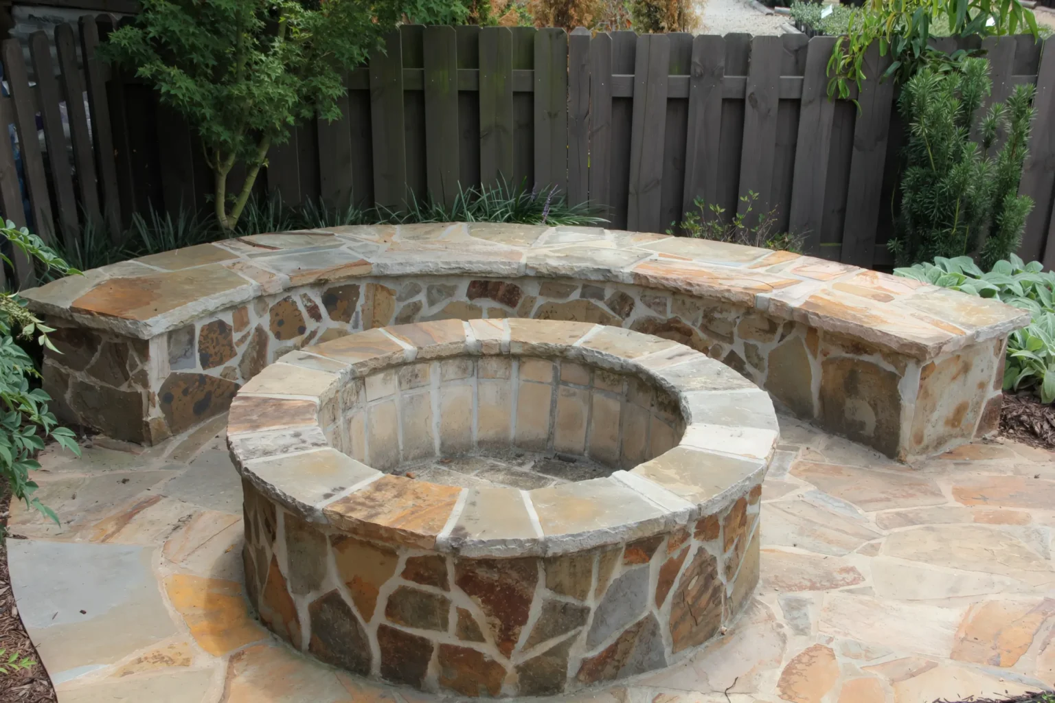 Circular stone fire pit with a built-in seating wall