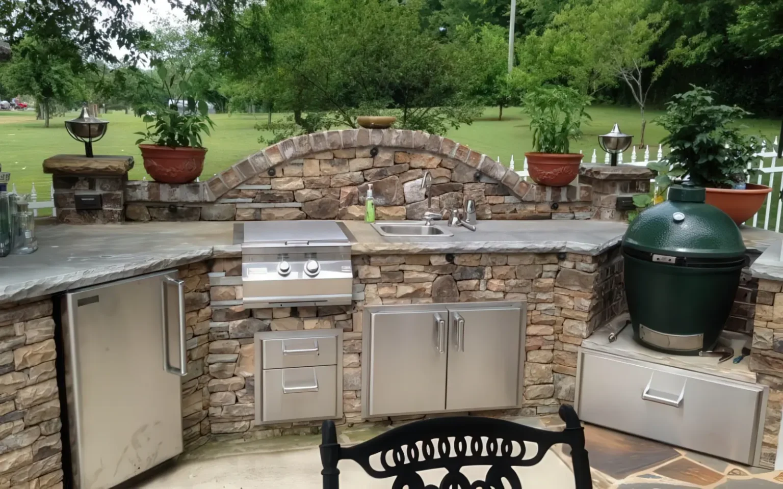 Stone outdoor kitchen with a built-in grill and smoker
